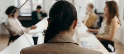 Five persons in a meeting room